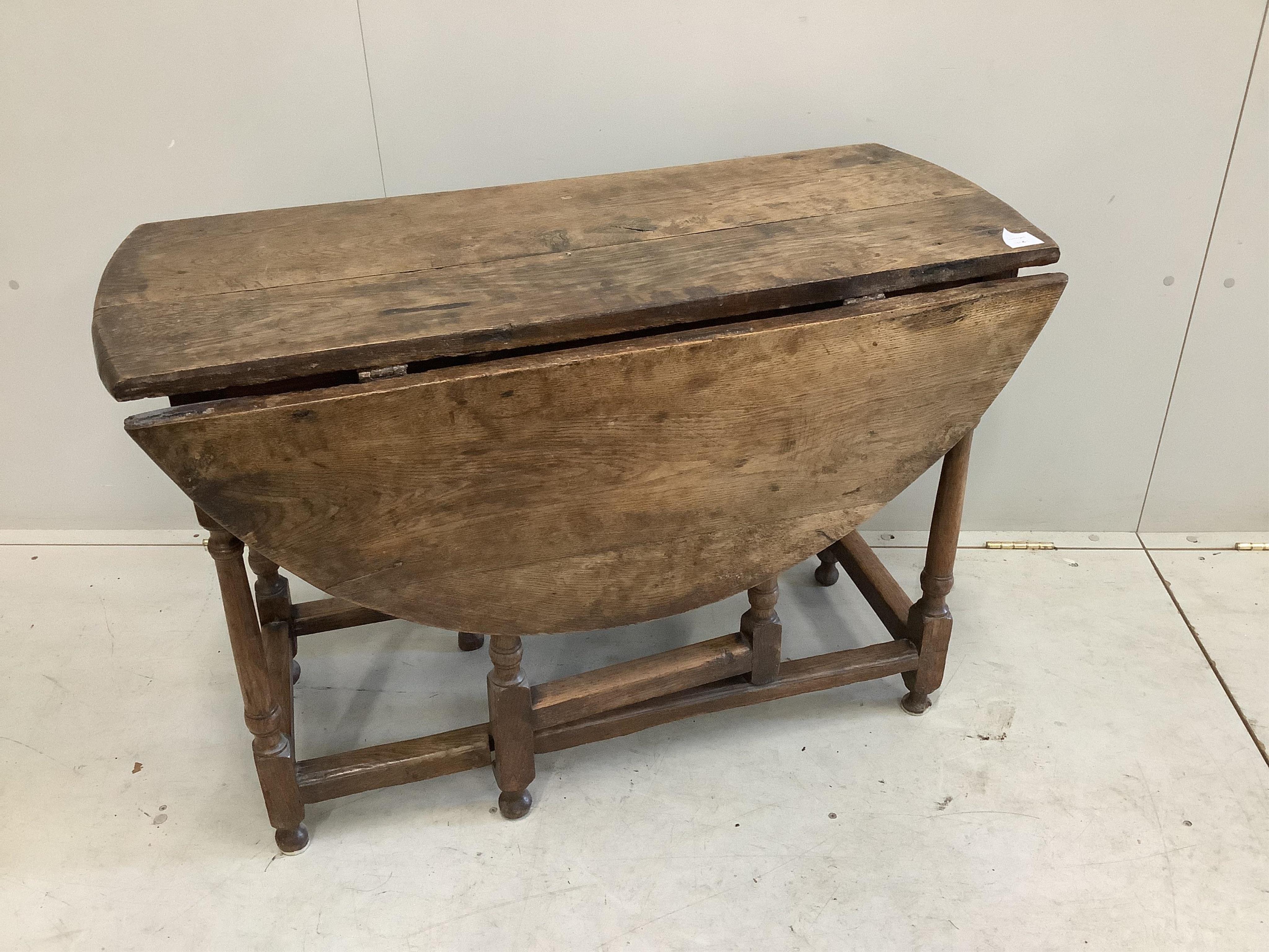 A small late 17th century oak oval topped gate leg table, width 100cm, depth 45cm, height 70cm. Condition - poor to fair